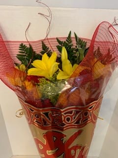Bouquet of yellow lilies wrapped in red mesh paper