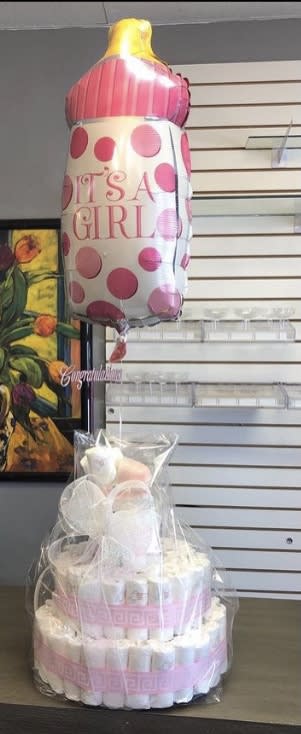 Baby bottle-shaped balloon above a diaper cake wrapped in clear plastic