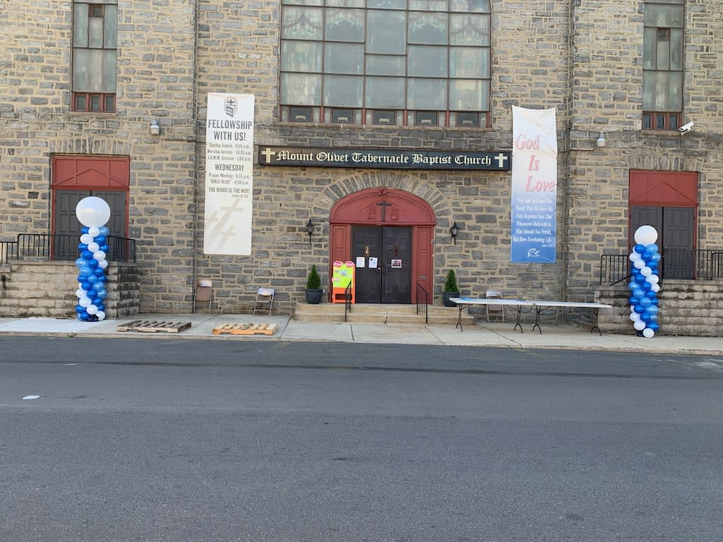 Church entrance with blue and white balloon columns and banners