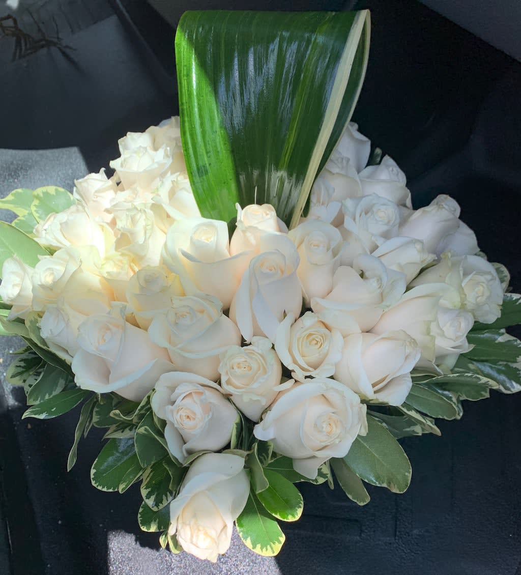 White rose bouquet with a large green leaf accent