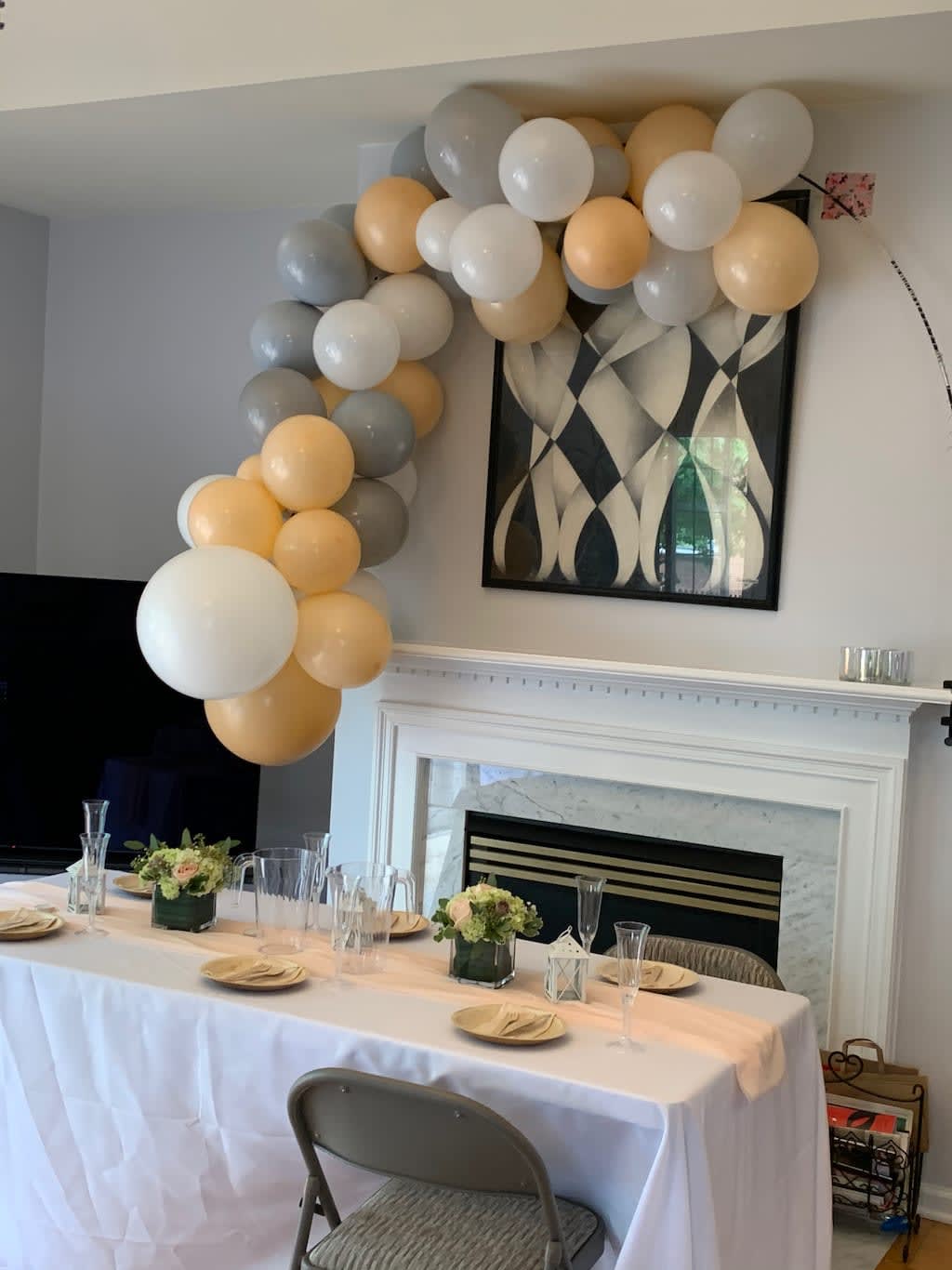Balloon garland in white, gray, and gold over a decorated table