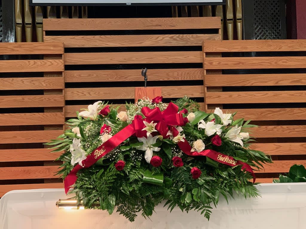 Large floral spray with white lilies and red roses on a stand
