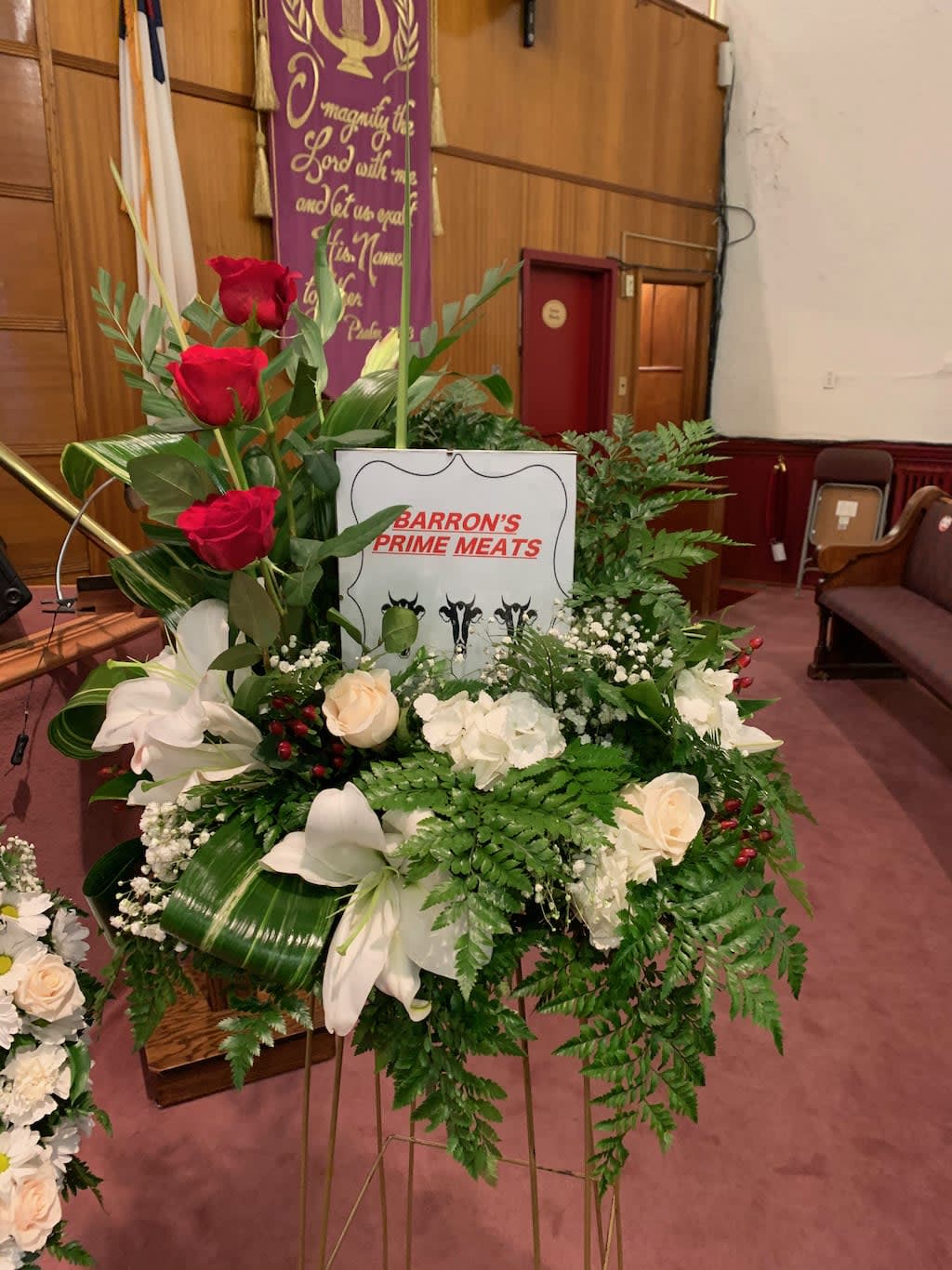Standing floral tribute with red and white flowers on a metal easel