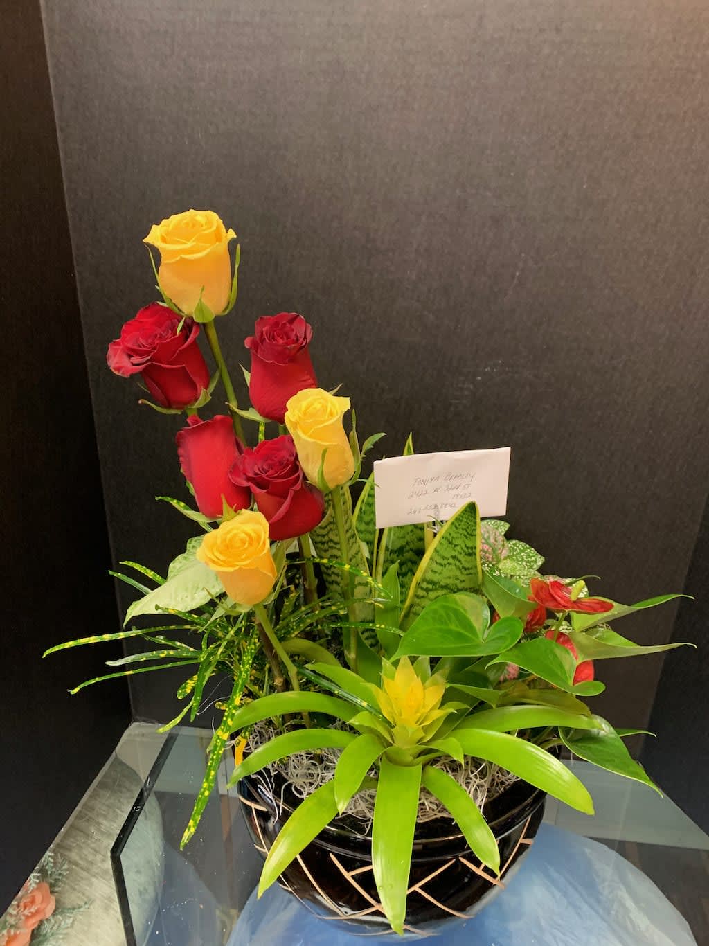 Arrangement of red and yellow roses in a black basket