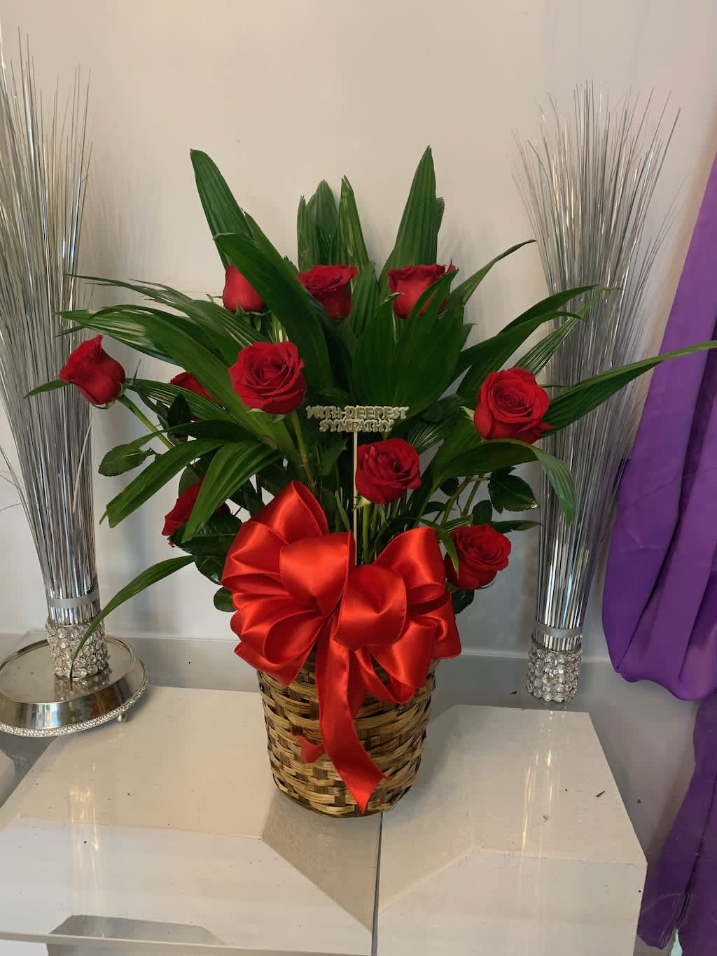 Red roses in a woven basket with a large red bow
