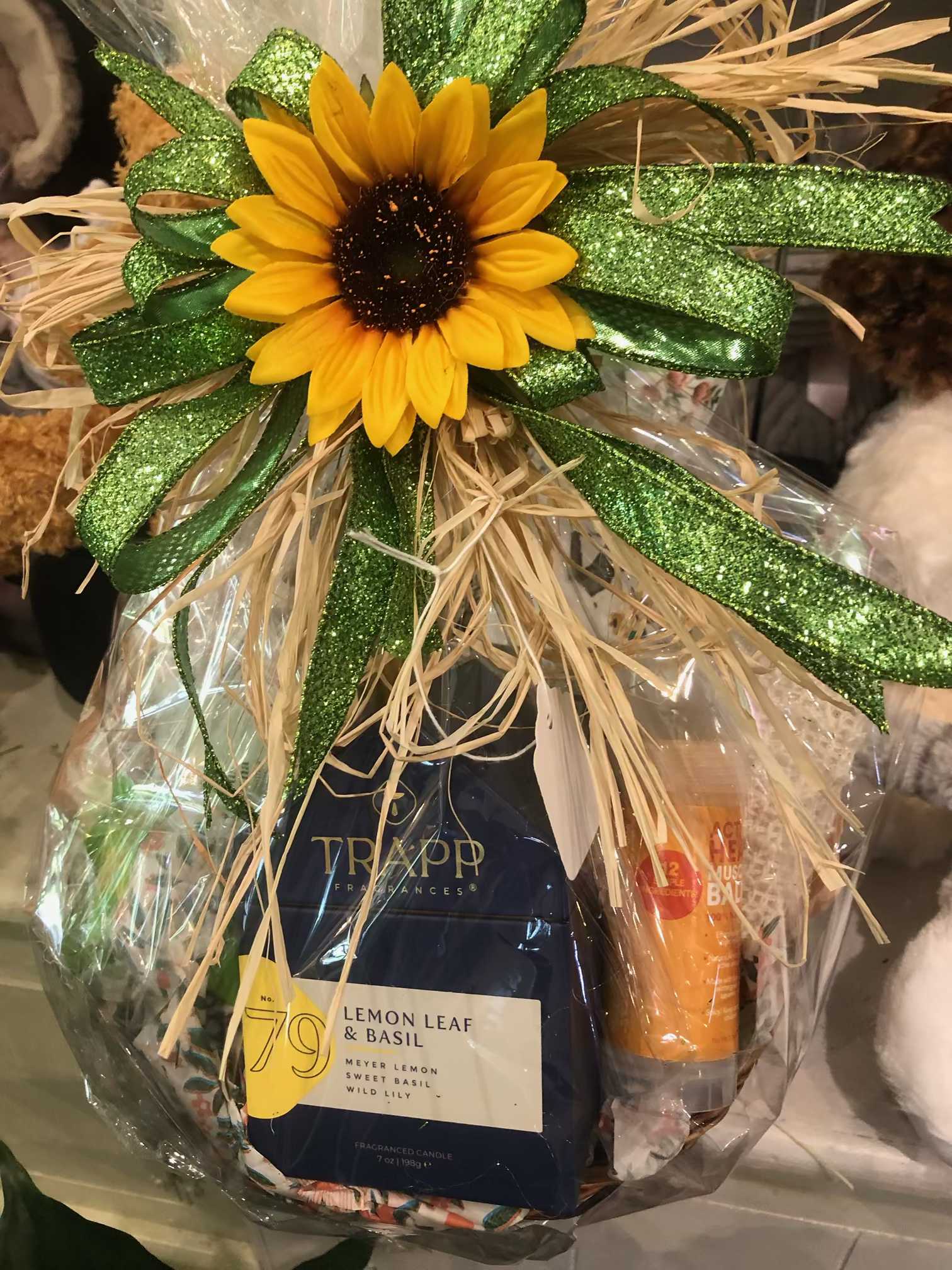 Gift basket with a sunflower topper and candles wrapped in clear cellophane
