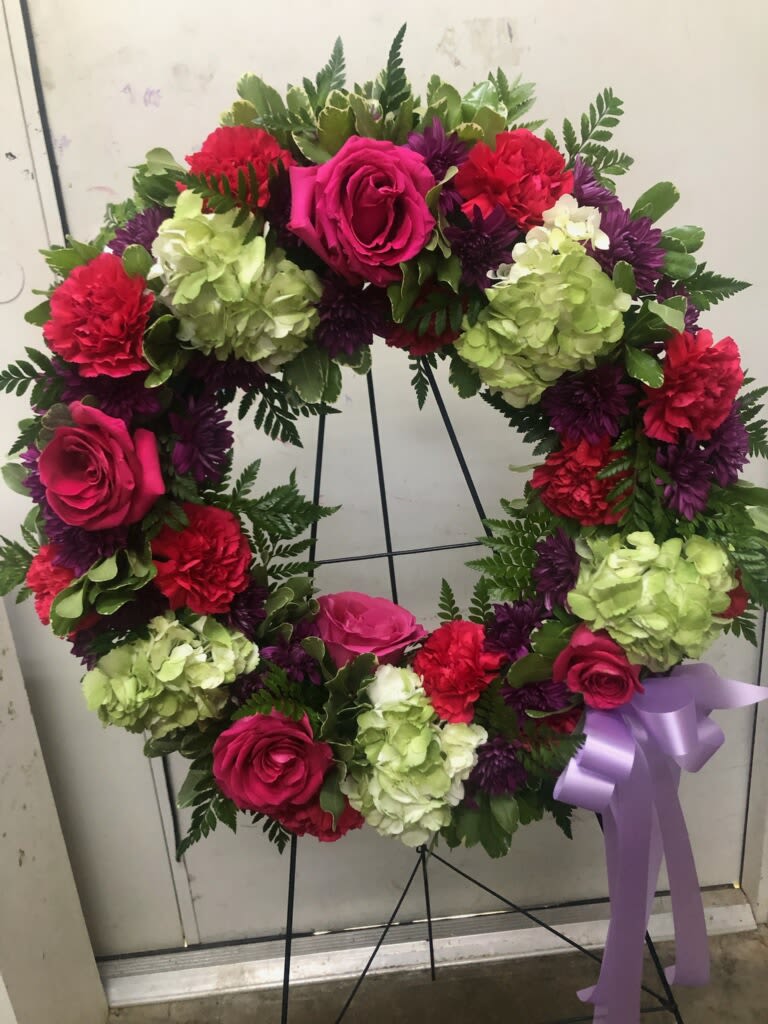 Heart-shaped floral wreath with pink roses, hydrangeas, and purple flowers