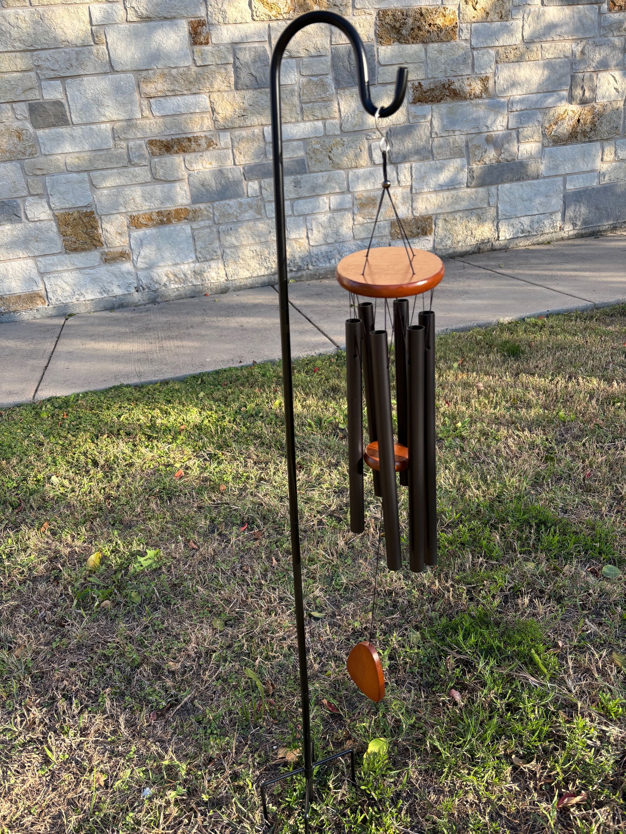 Outdoor wind chime with black tubes and wooden discs