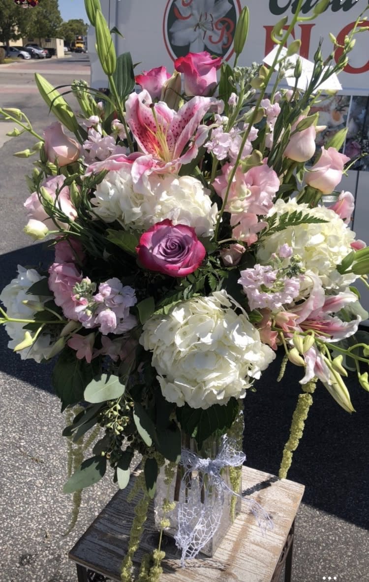 Pink and white mixed bouquet with lilies, roses, and hydrangeas in a clear vase