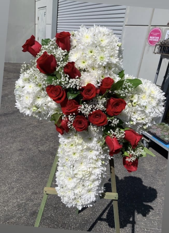 Standing cross arrangement of red roses and white chrysanthemums