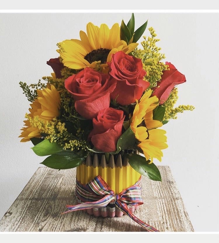 Bouquet of red roses and yellow sunflowers in a pencil vase