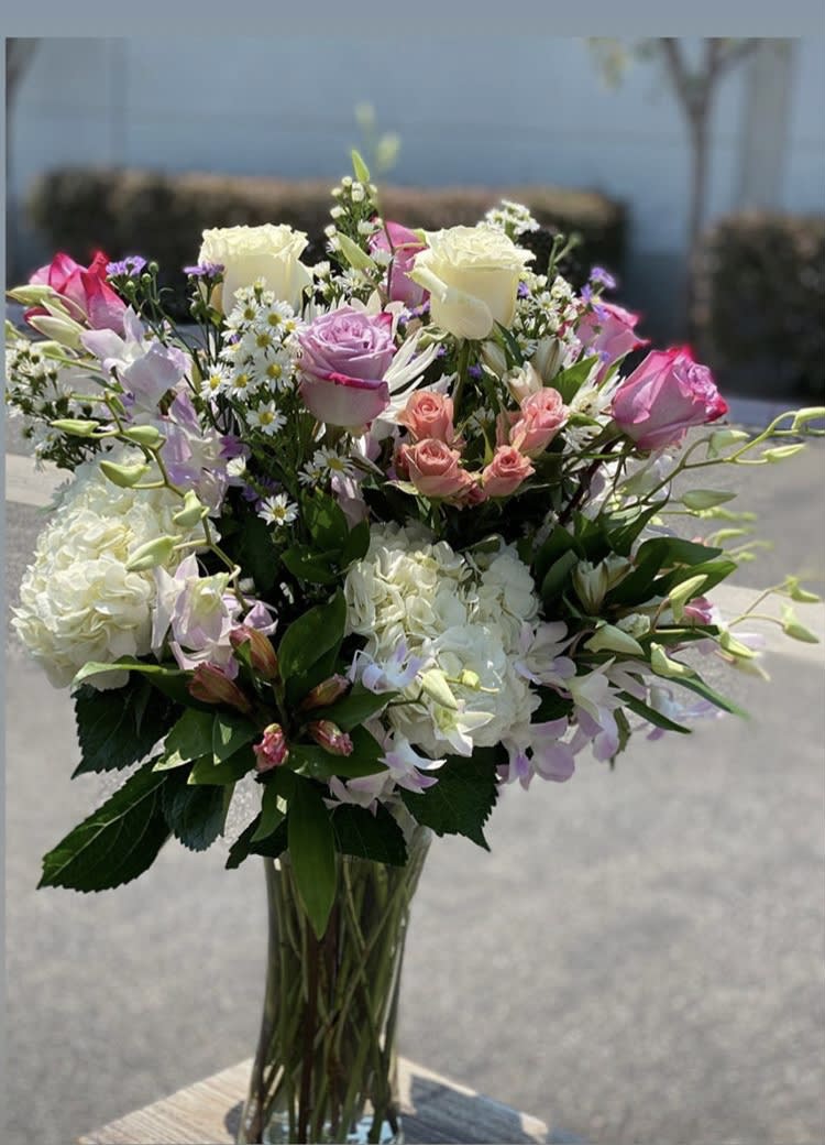 Mixed bouquet of pink and white roses in a clear glass vase