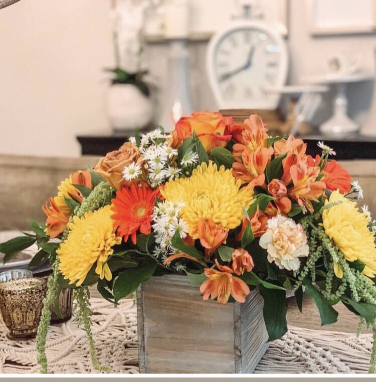 Orange and yellow floral arrangement in a wooden box centerpiece