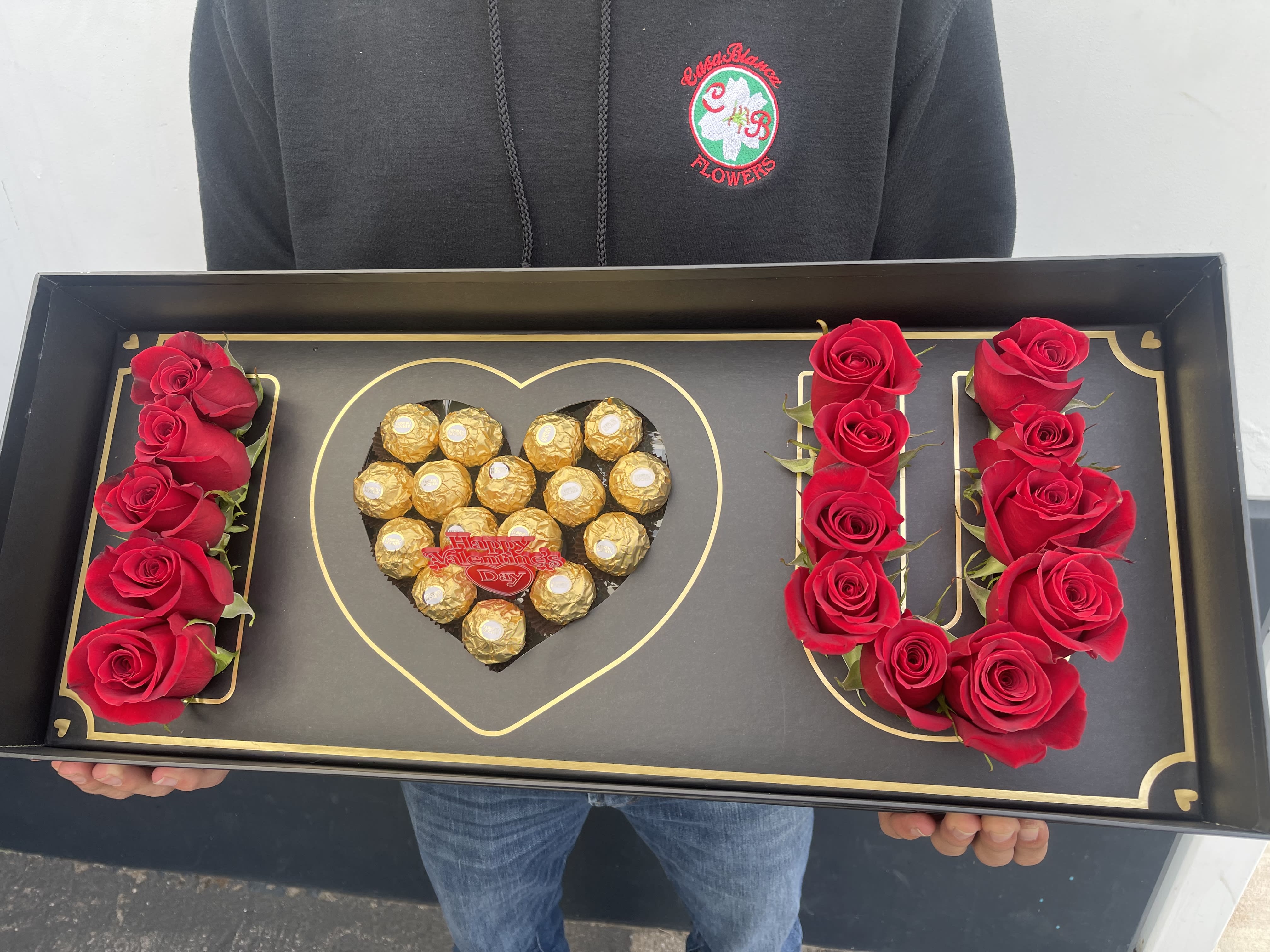 Black gift tray with red roses and Ferrero Rocher chocolates arranged as LOVE