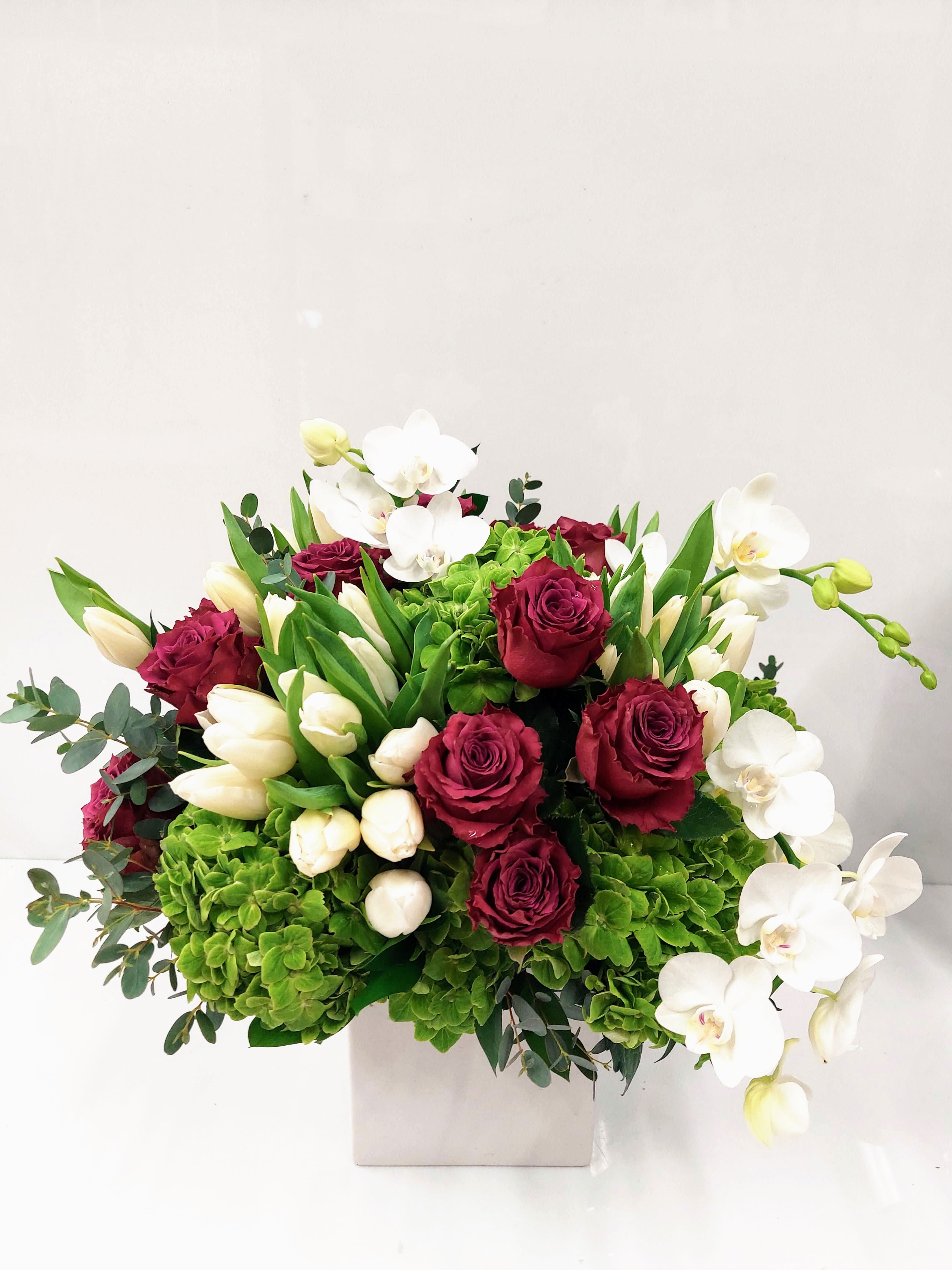 Garden of Blooms - Vase of beautiful blooms of hydrangeas roses and tulips but oh with abundance of orchids. 