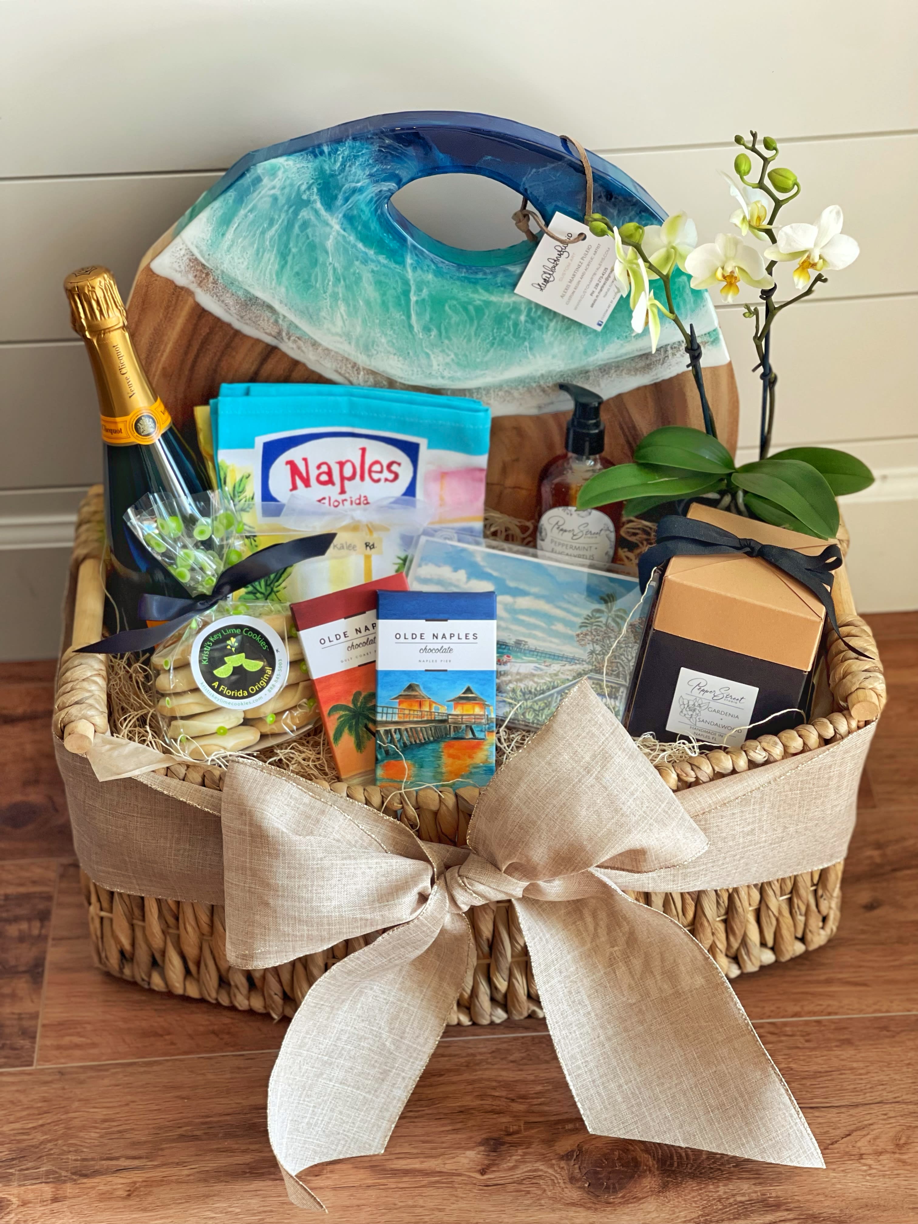 Gift basket with orchids, chocolates, cookies, and a champagne bottle