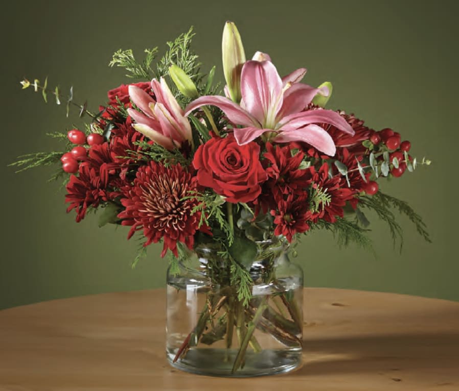 Red and pink floral arrangement in a clear glass vase