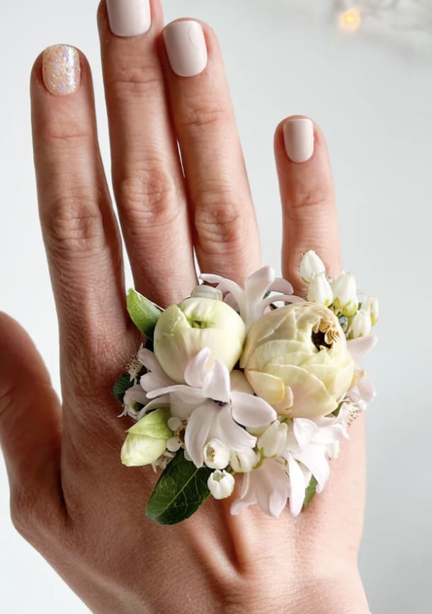 Small floral ring with cream and white blooms on a hand