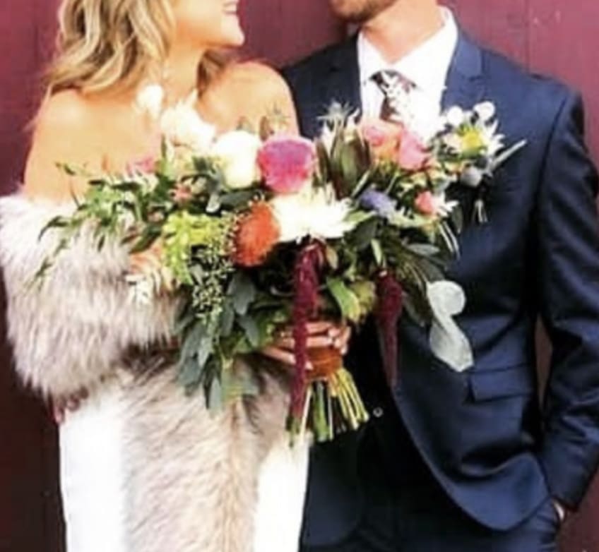 Bride and groom holding a colorful wedding bouquet