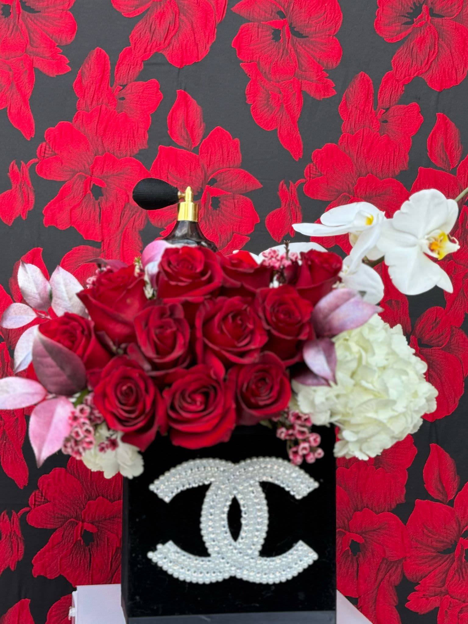 Velvet Romance: Dozen Roses Floral Arrangement - A luxurious arrangement of a dozen freshly cut, premium roses, along with other romantic flowers, carefully placed in an elegant velvet designer box. The rich, velvety texture of the box enhances the beauty of the flowers, making it a timeless gift. Whether celebrating love, admiration, or friendship, this exquisite bouquet is an embodiment of elegance, design and sophistication.