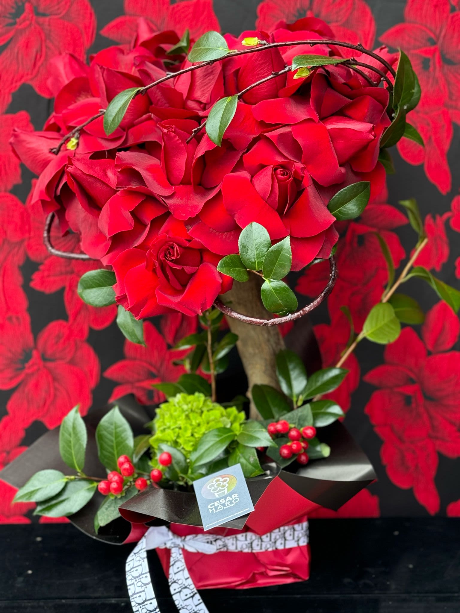 El Pecado de Eva  - A romantic and enchanting arrangement of carefully selected roses shaped into a heart, designed to capture the essence of love and passion. This heart-shaped rose tree features vibrant red blooms, symbolizing the tree where Eve picked the forbidden fruit, filled with deep affection, admiration and love. Make your evening the forbidden one with this arrangement. 