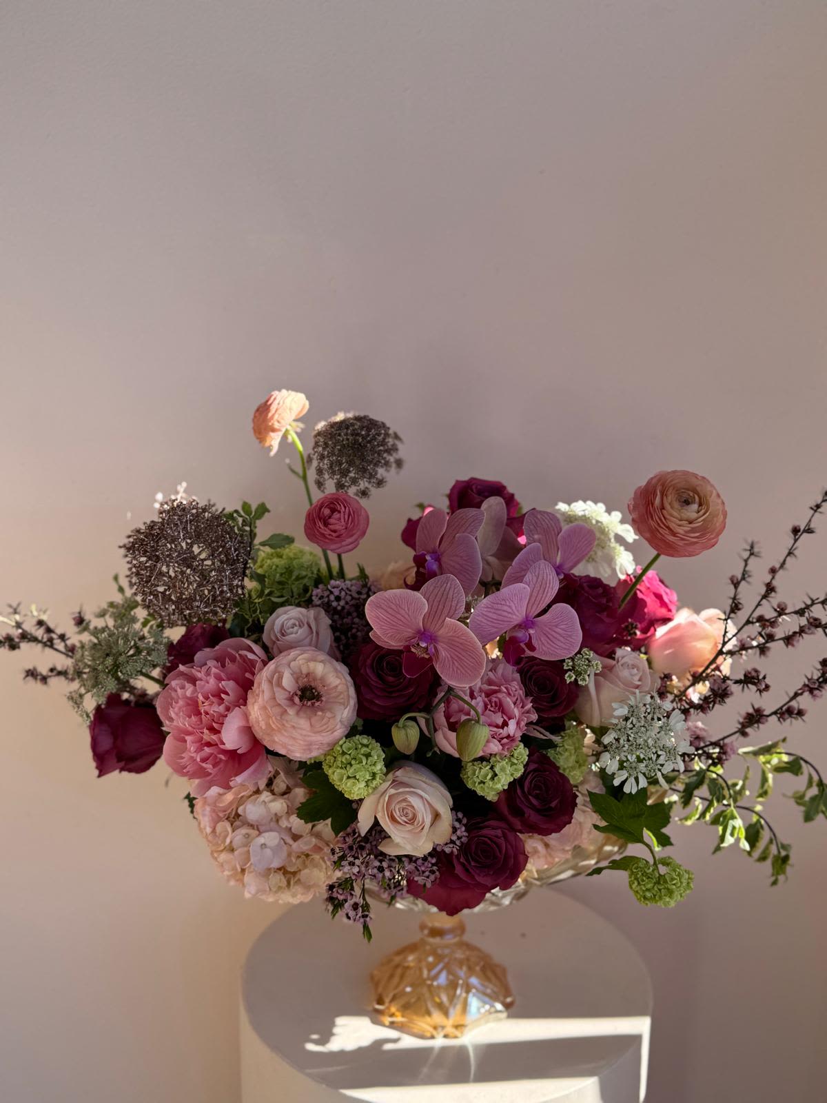 Mixed pink and burgundy bouquet in a decorative glass vase