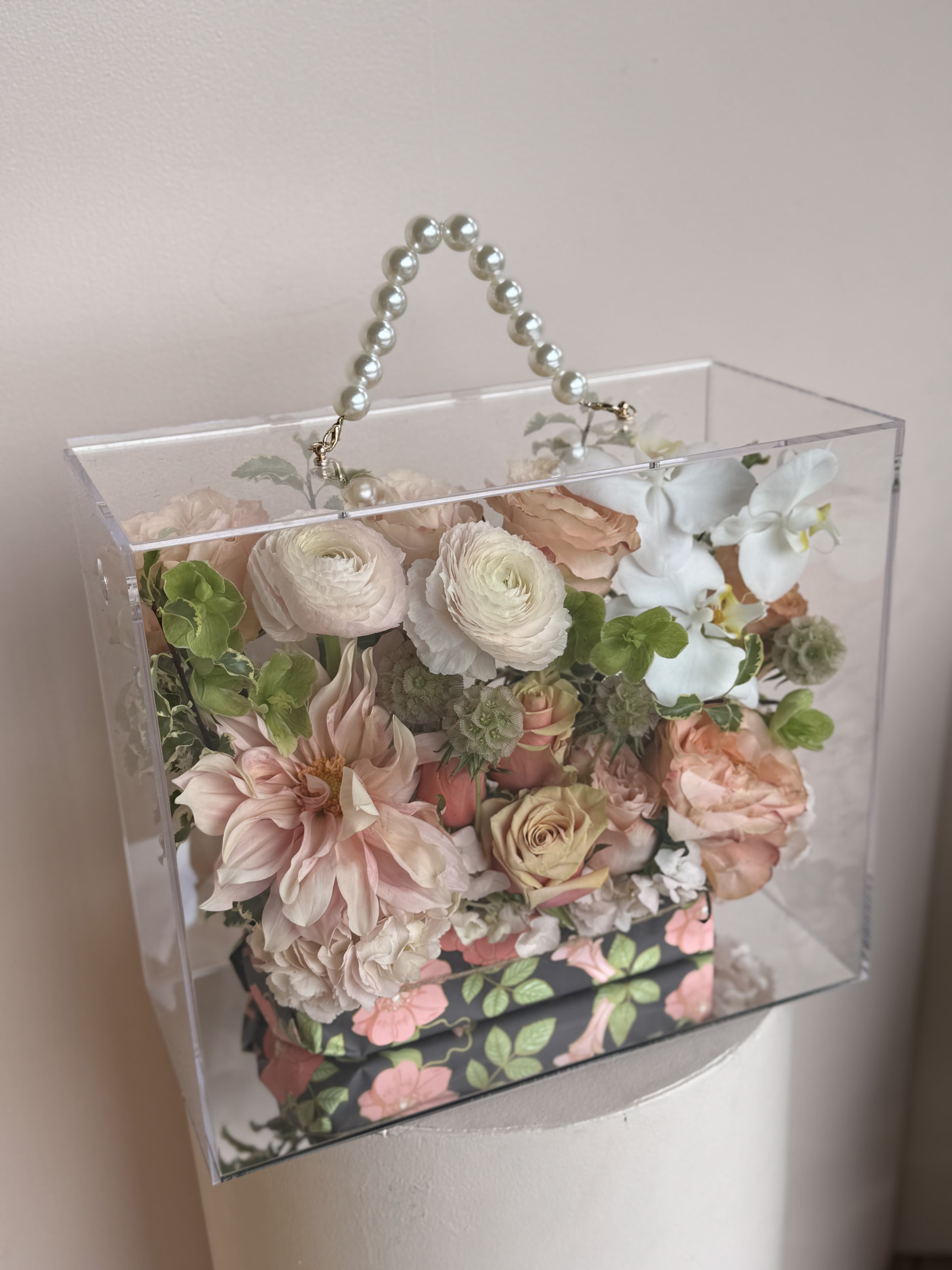 NOVA ERA FLOWERS - Very Trendy and In Clear Acrylic Flower Gift Box in a shape of bag with pearl handle beautifully designed with blush flowers and rich accents of novelty flowers 