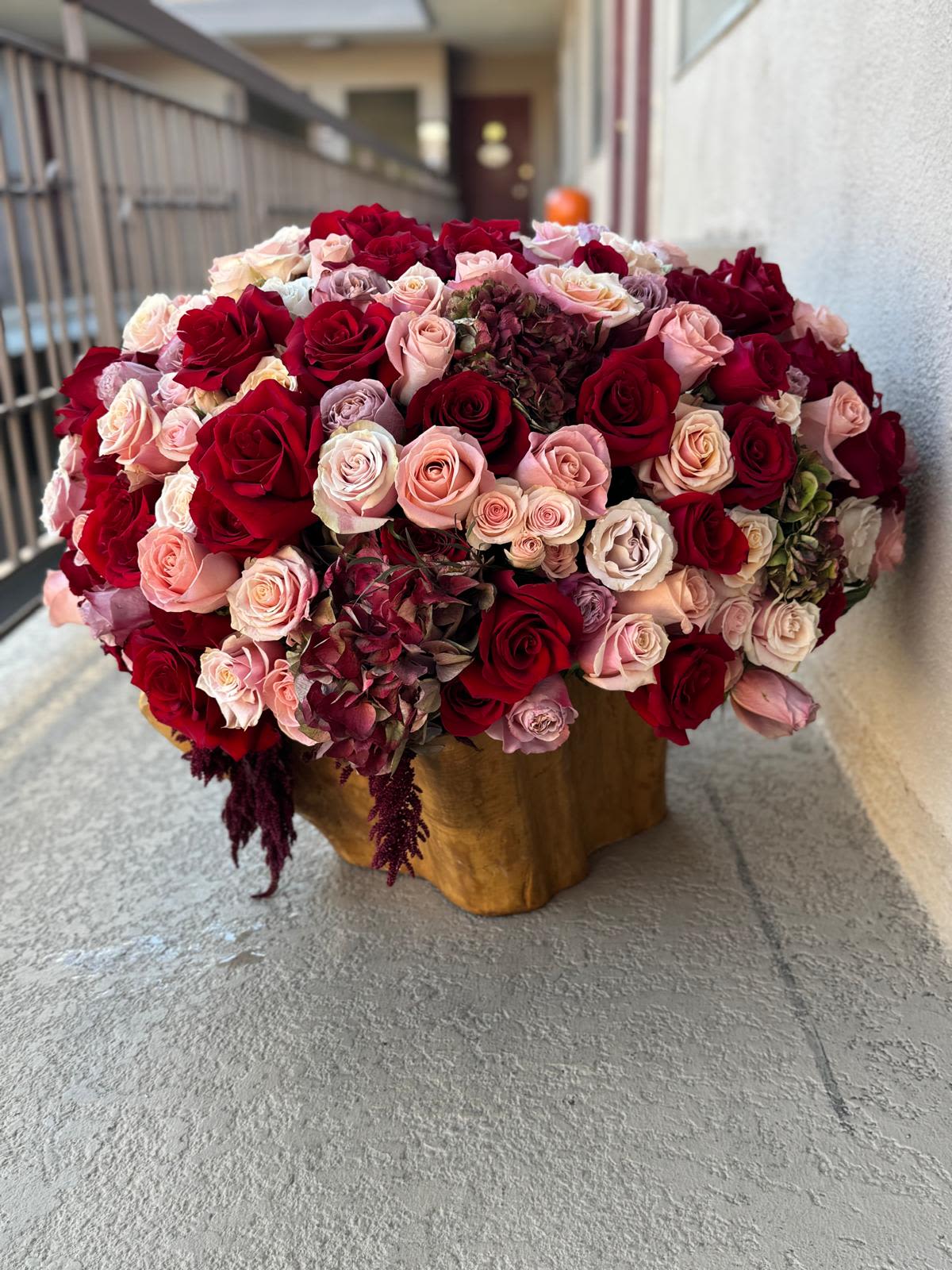 Luxury Blooms - When lavender, reds, pinks and burgundy say everything words can’t. Designed by a man who understands romance. Carved in wood, wrapped in roses, made to capture hearts. 