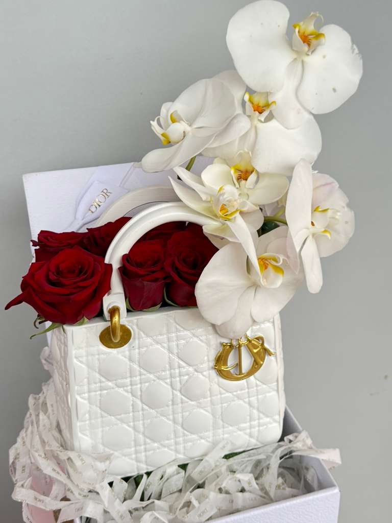 Designer Dior  - Elegant red roses and Sophisticated Orchids artfully arranged in a stunning white Dior. 