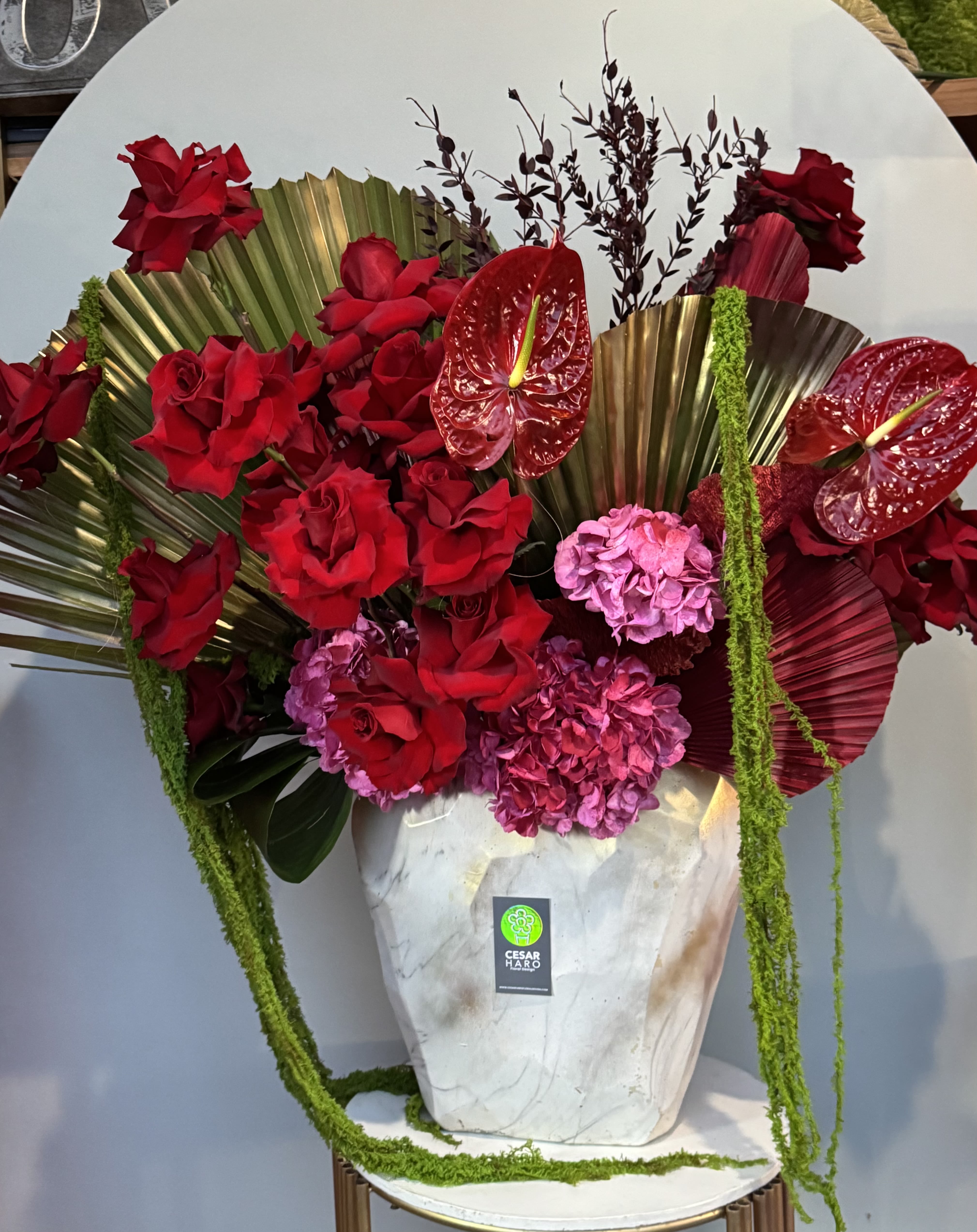 Tropical Romance  - Large white base with vibrant reds and pinks, accented by graceful palm fronds for height and drama. 