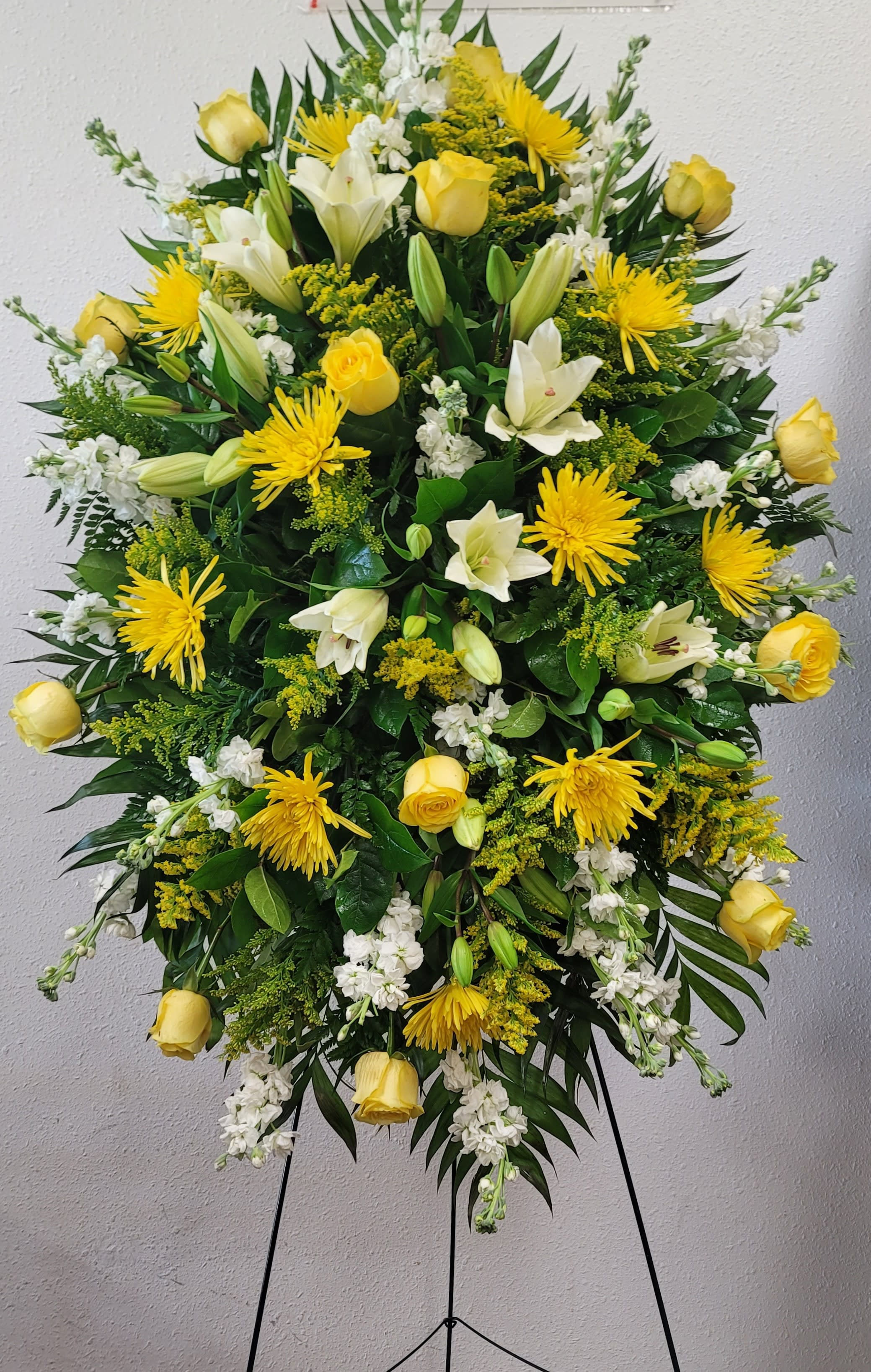 Large yellow and white floral standing spray on an easel