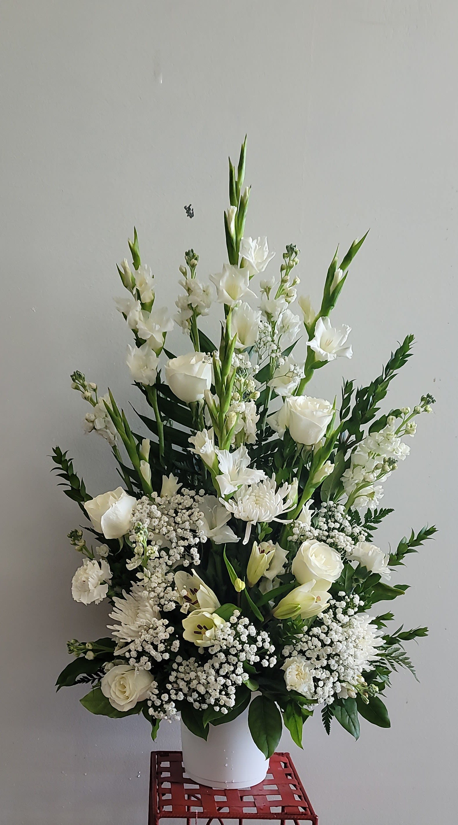 White floral arrangement in a white vase with tall blooms