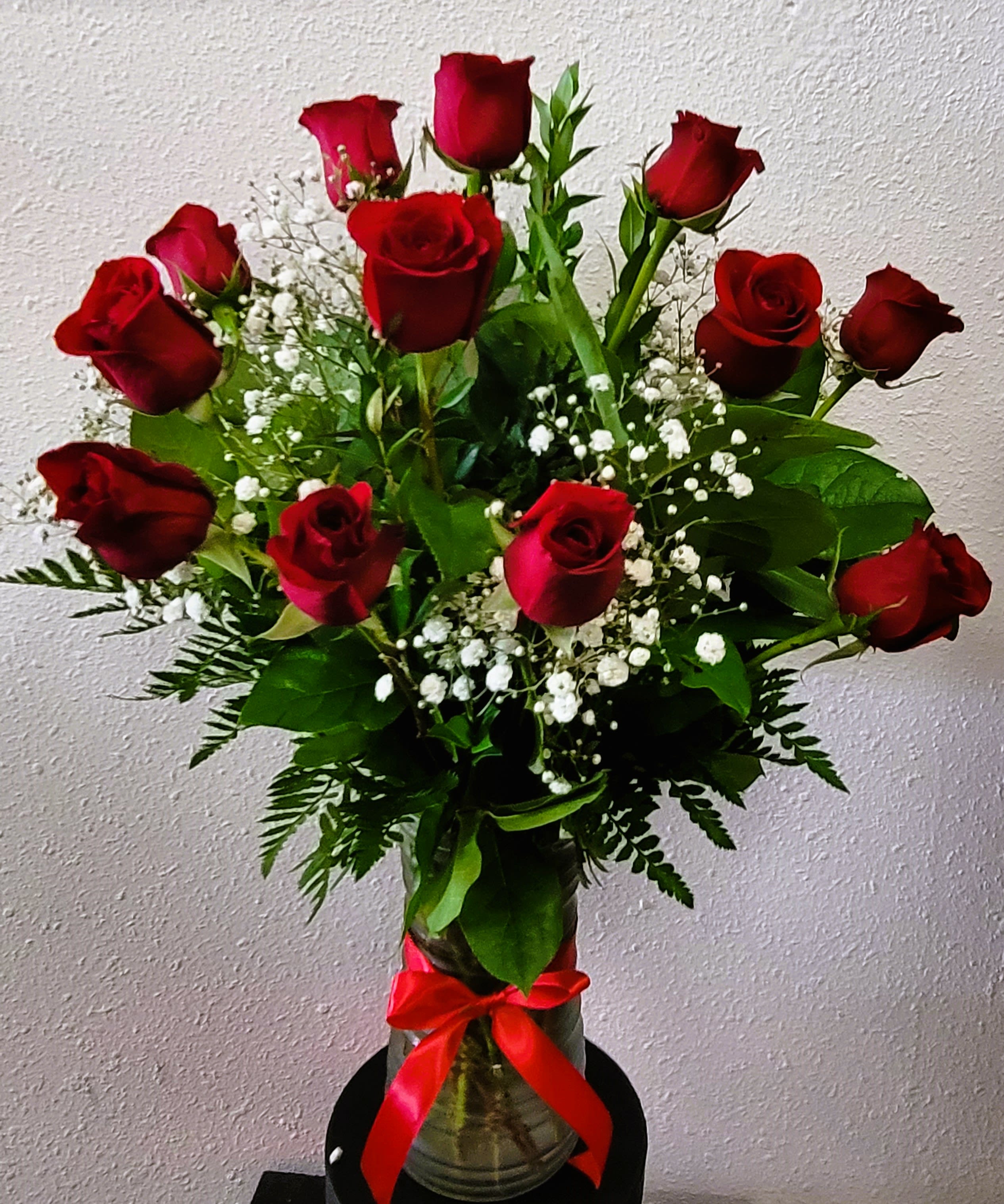 Bouquet of red roses with baby's breath in a glass vase