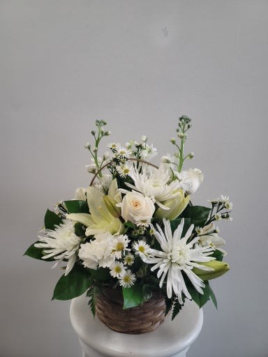 White floral arrangement in a woven basket