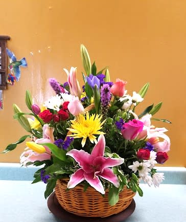BASKET ARRANGEMENT WITH MIXED COLOR FLOWERS - MIXED FLOWERS LIKE, IRIS, TULIPS, ROSES, LIATRICE AND MORE. 