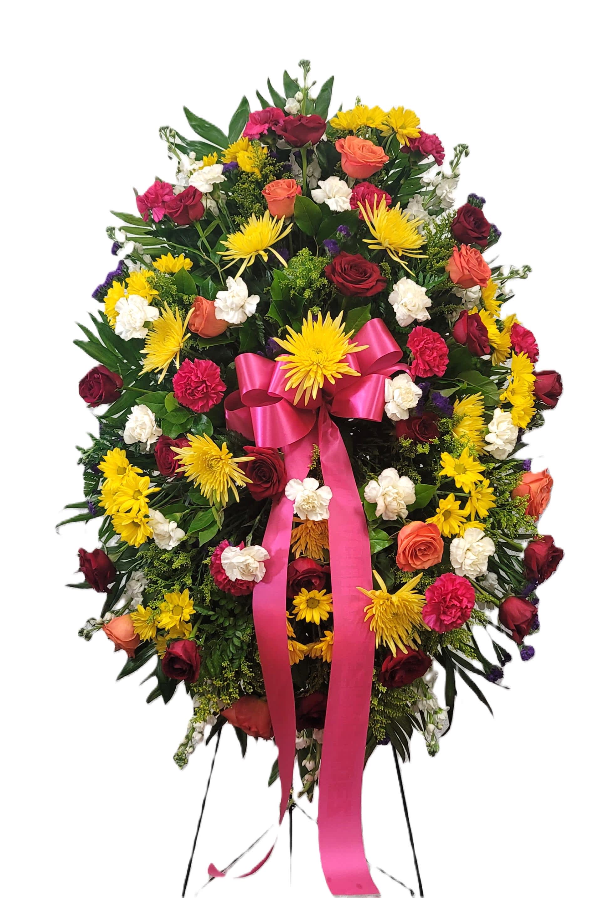Large standing floral wreath with roses, chrysanthemums, and a pink ribbon