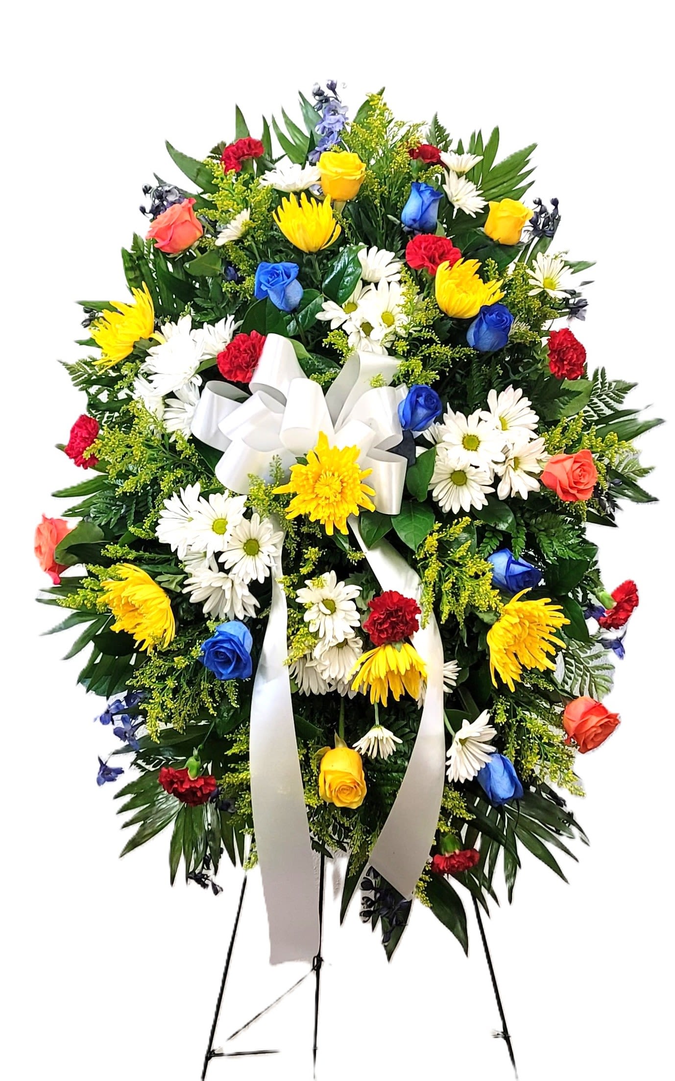 Standing floral spray with multicolored roses, daisies, and a white ribbon