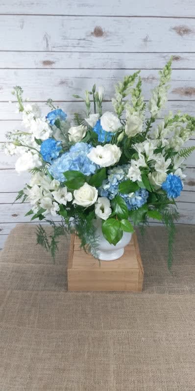 Blue and white floral arrangement in a white vase