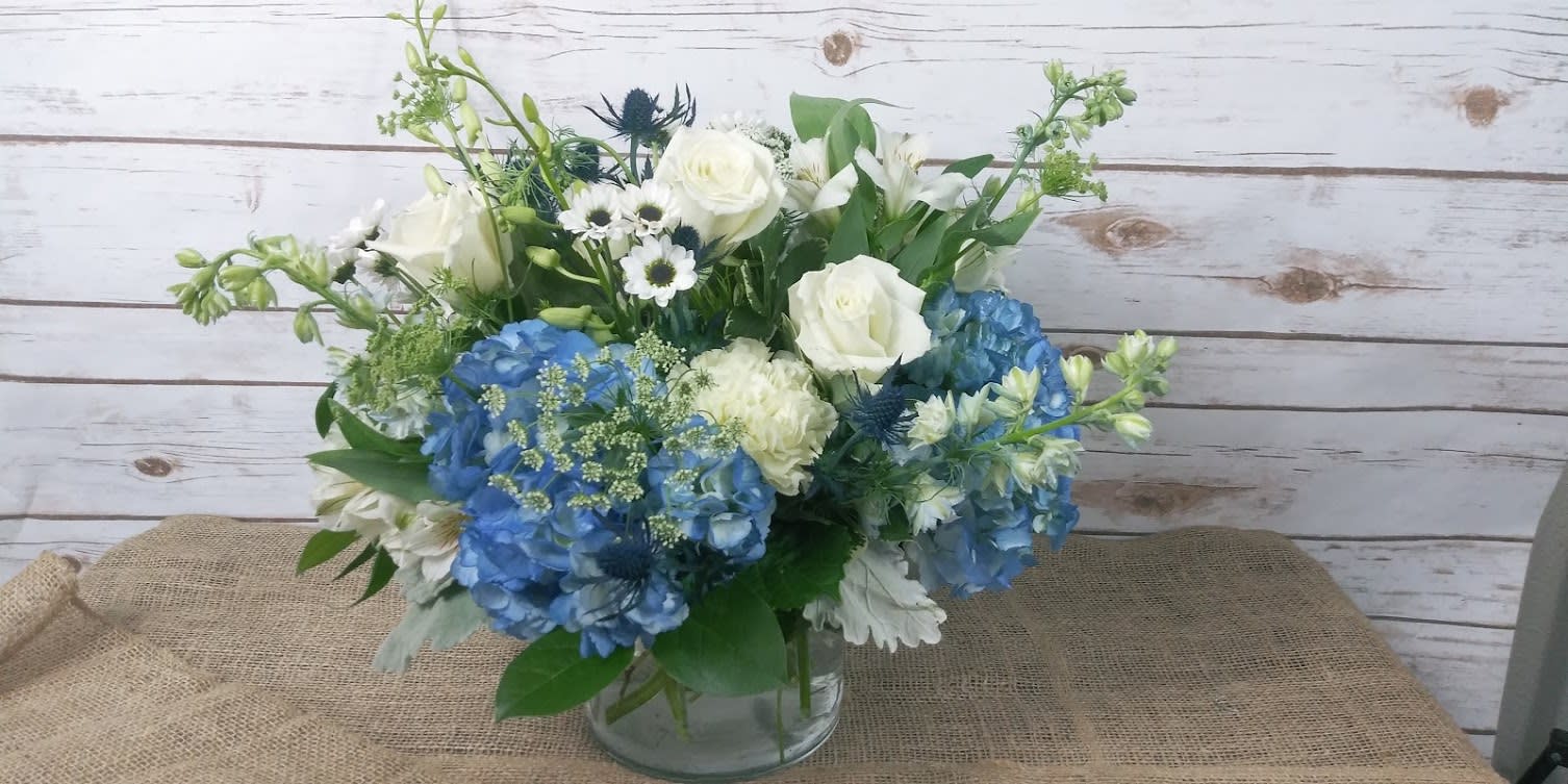 Blue and white flower arrangement in a clear glass vase