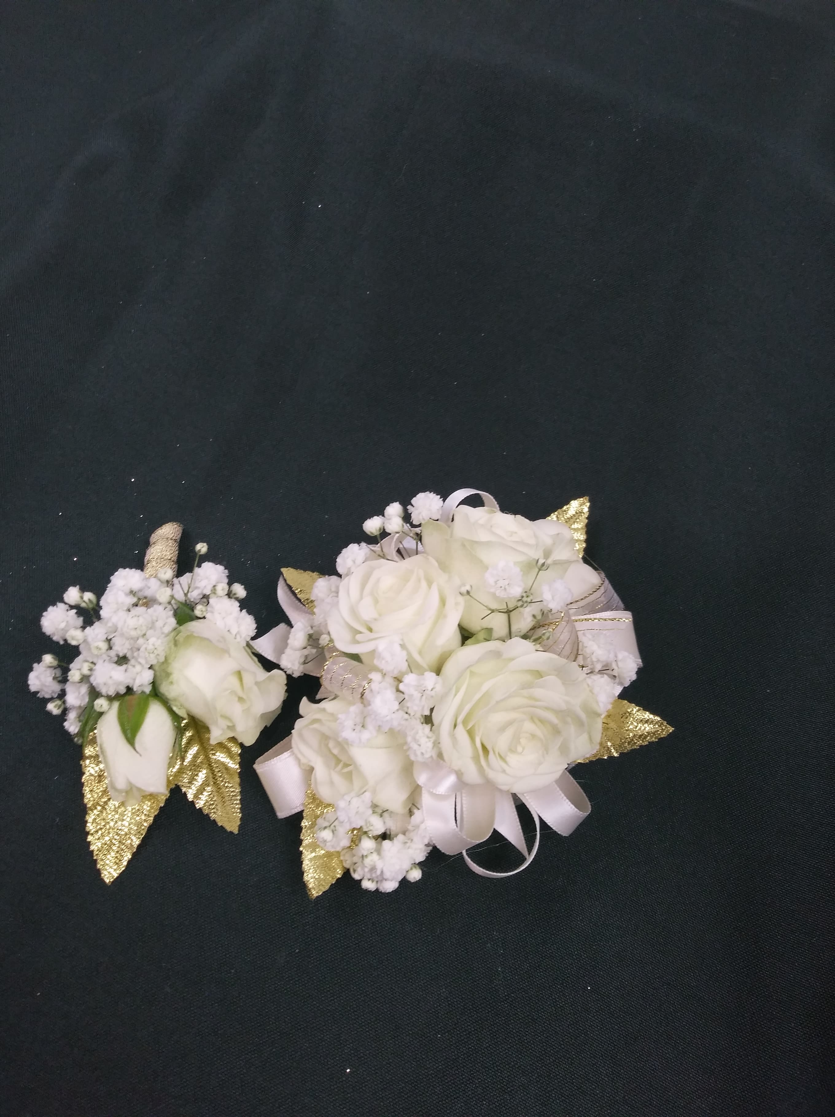 White rose corsages with baby's breath and gold accents