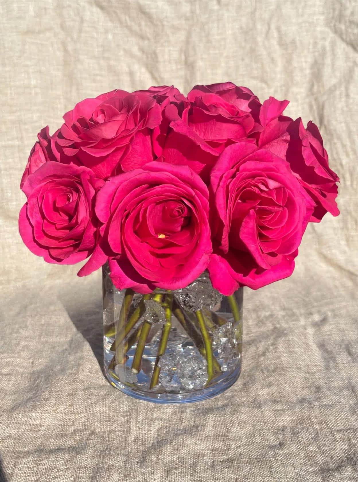 Hot pink roses arranged in a clear glass vase