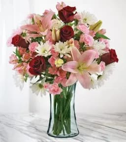 Bouquet of pink and red flowers in a clear glass vase