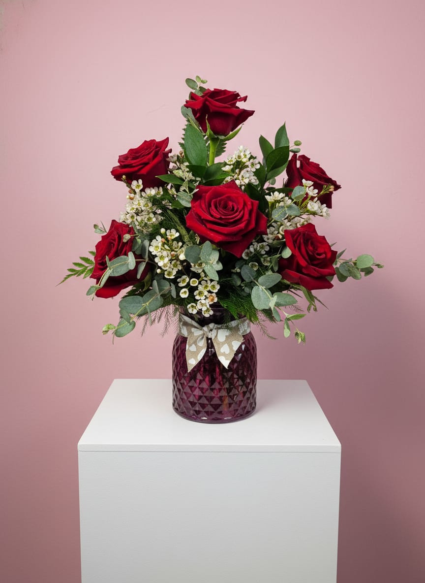Rose Charm Vase - A half dozen roses with a variety of greenery and eucalyptus come together for a lovely arrangement. A stylish and sweet way to dress up any space, send this arrangement for Valentine's Day, Mothers Day, Sister's Day, or Women's Day.  All orders will be fufilled with RED roses but if you'd like another color, please specify in your order and we will try our best to accomodate!    APPROXIMATE DIMENSIONS: 15" W x 10" H