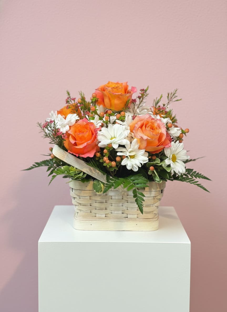 Basket arrangement of orange roses and white daisies