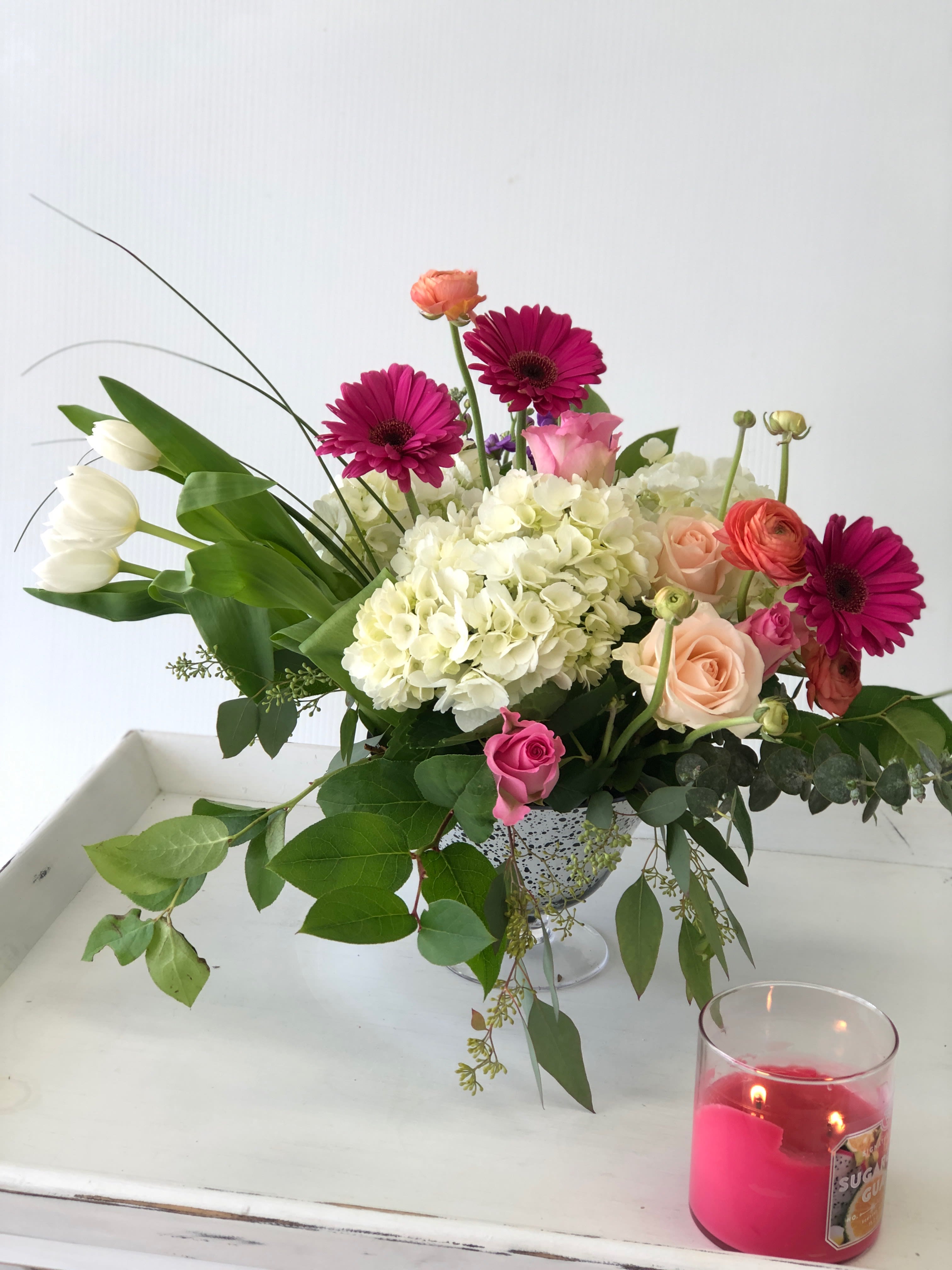 Silver extraordinaire - A silver footed vase with hydrangea tulips ranunculus gerber daisies and roses
