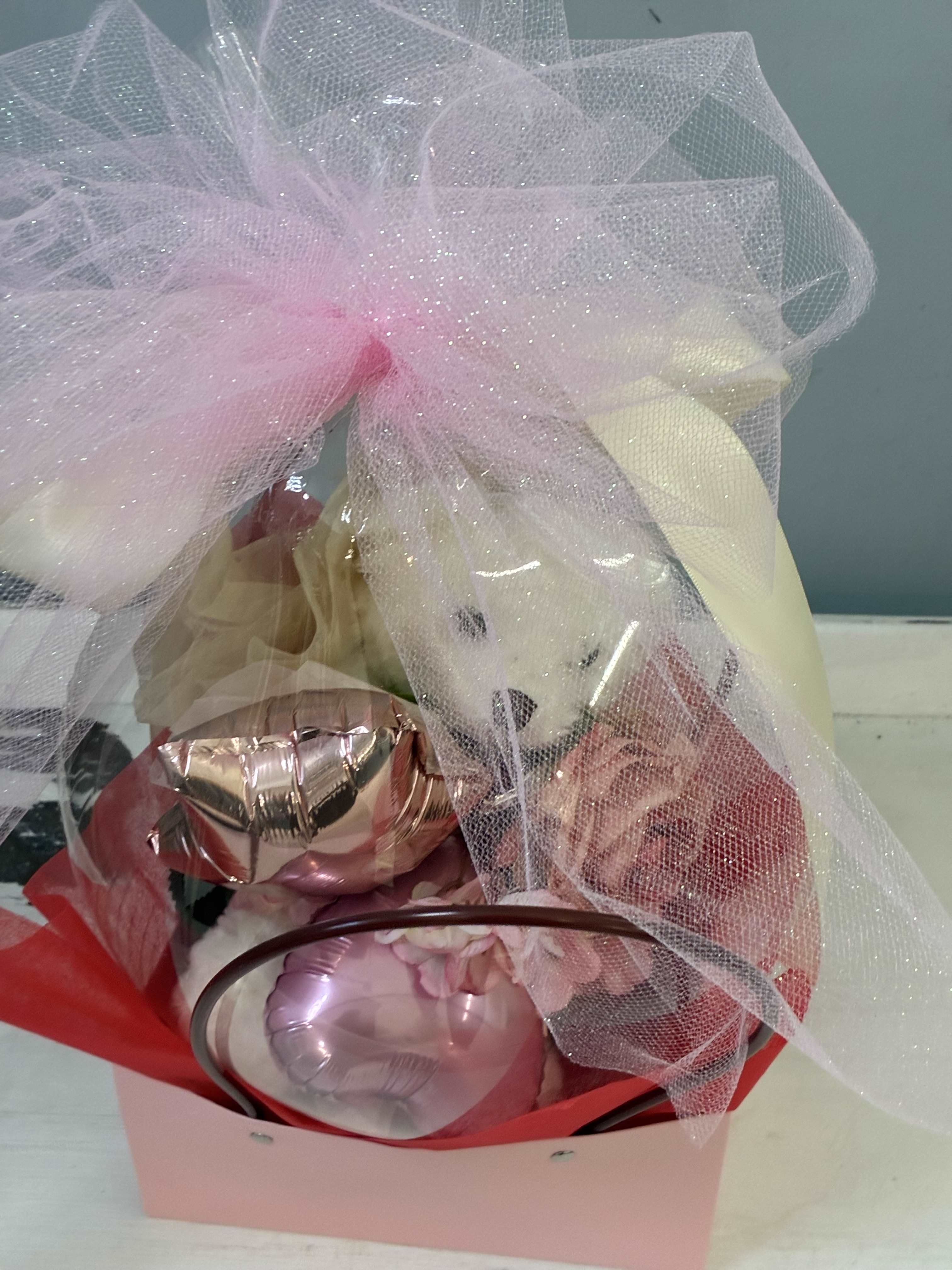 Gift basket with pink and white balloons wrapped in tulle