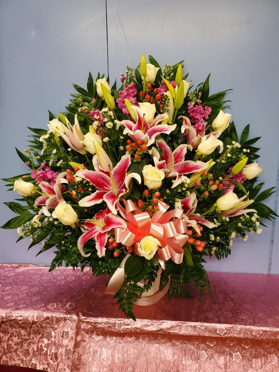 Large bouquet of pink lilies and cream roses with a satin ribbon