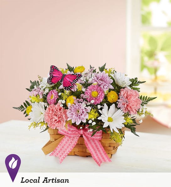 Pink and white mixed flower basket with a butterfly decoration