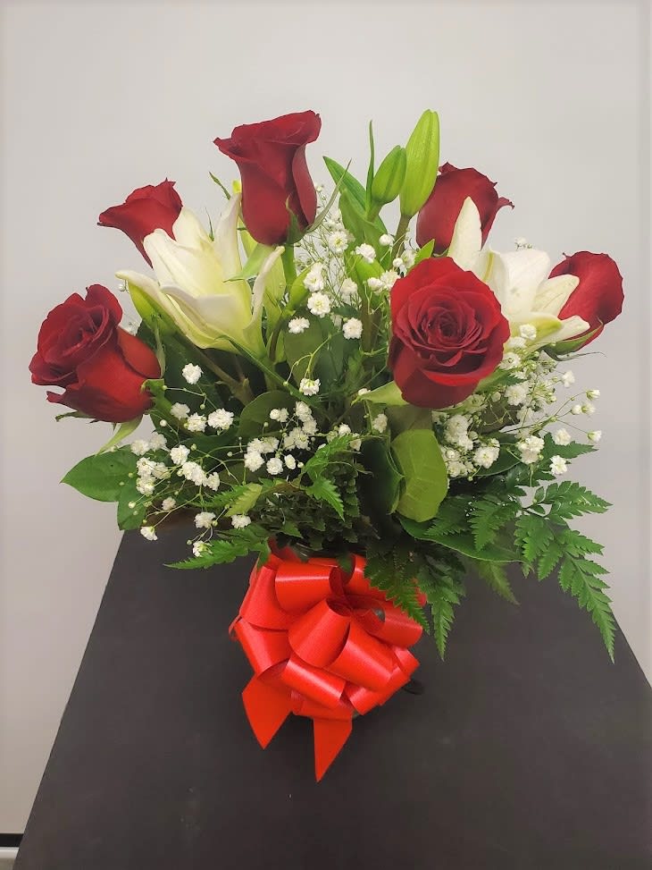 Bouquet of red roses and white lilies with a red ribbon bow