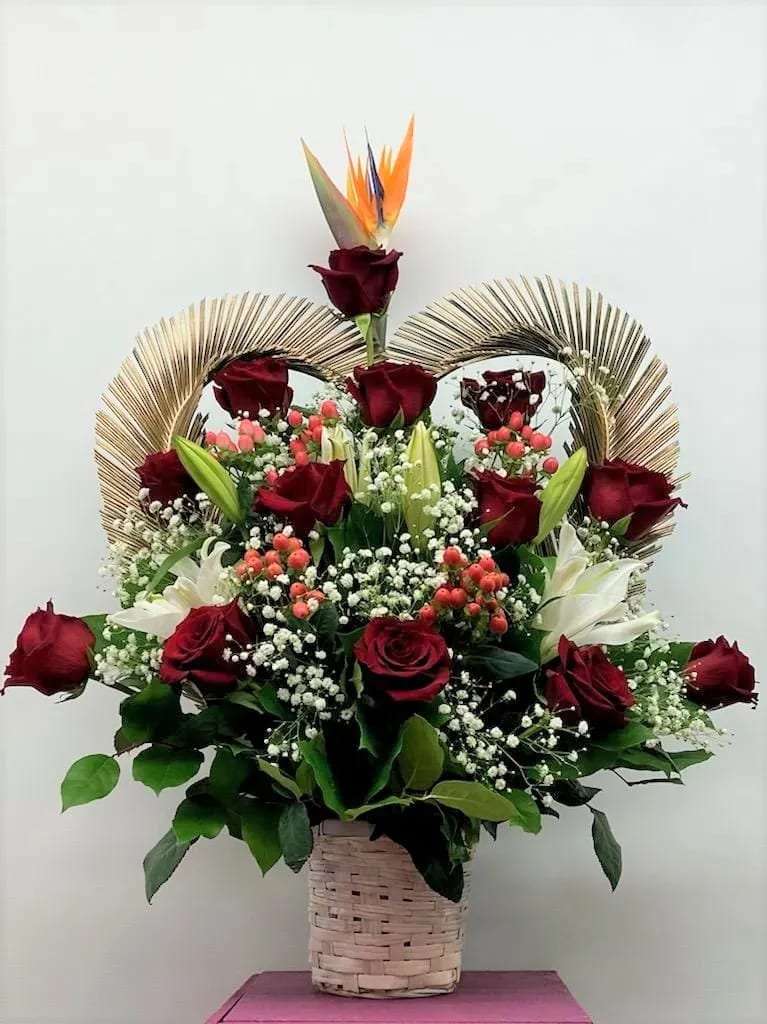 Basket arrangement of red roses, white lilies, and bird of paradise